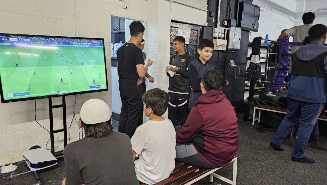 Young people watching a game on a TV screen at Friday Youth Club